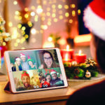 Young woman having a Christmas video call with her happy family.